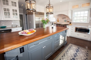 Gray island cabinetry with wood countertop