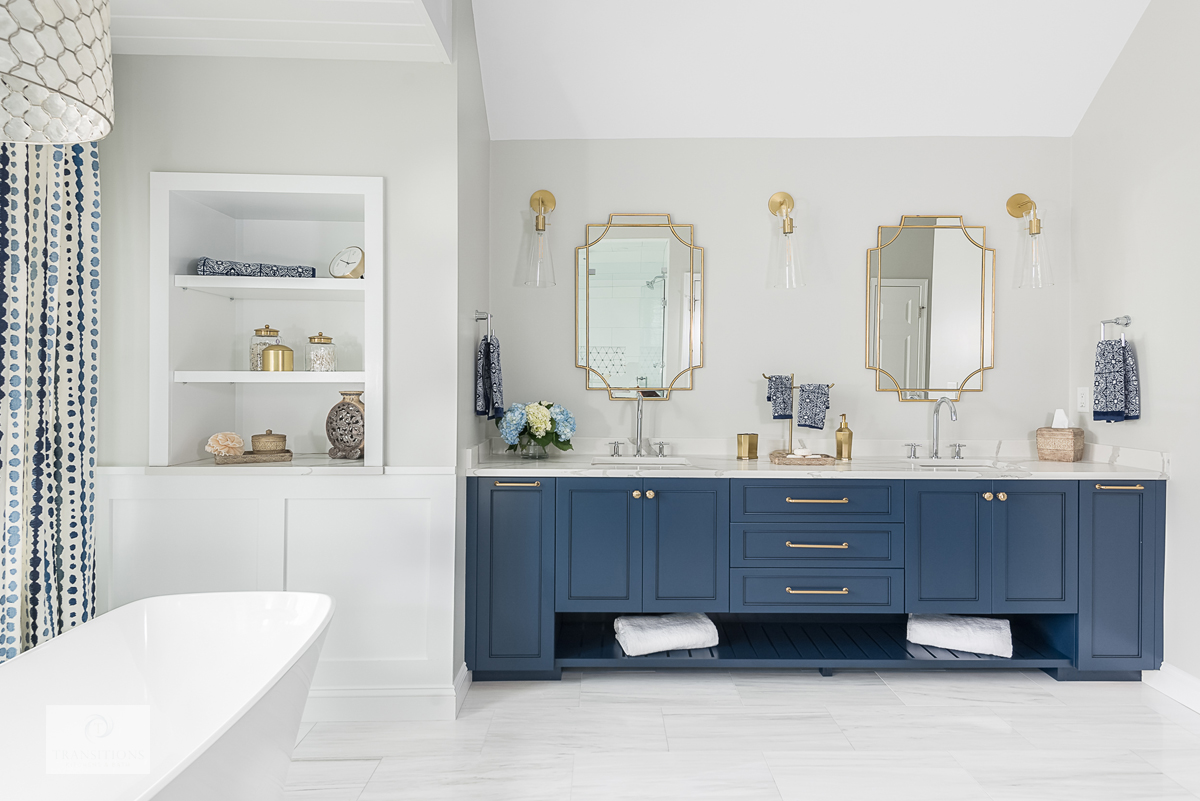bathroom with blue vanity cabinet and recessed shelves
