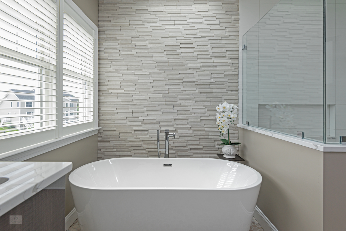 freestanding tub with textured tile wall
