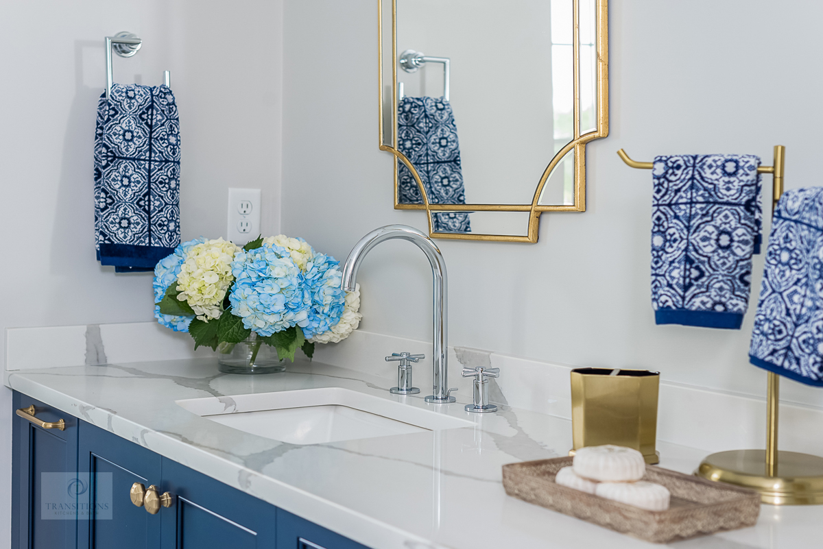bath design with blue vanity cabinet and countertop accessories