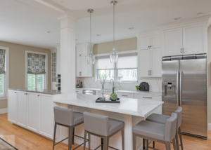 white kitchen island with tabletop end and gray barstools
