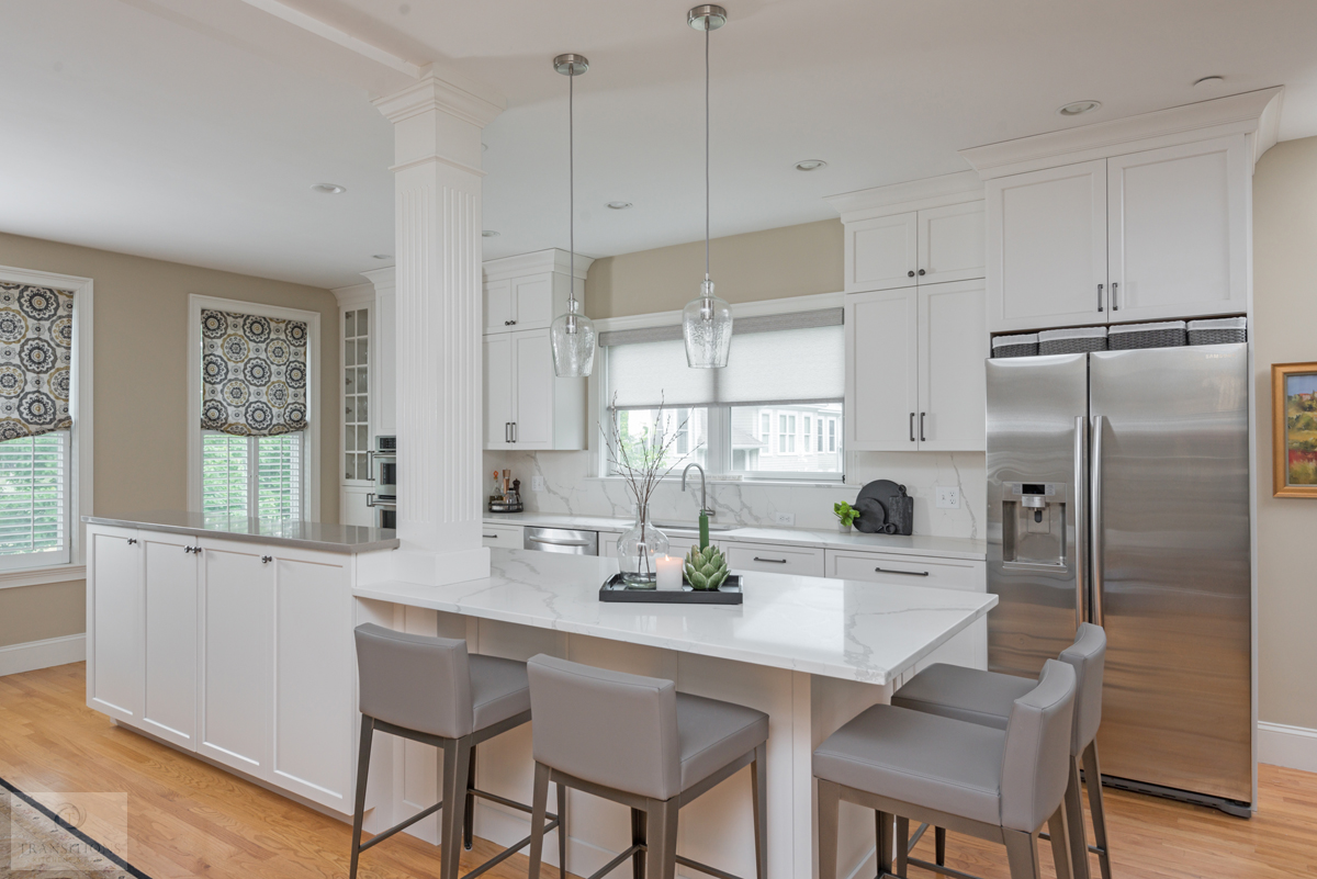 white kitchen island with tabletop end and gray barstools